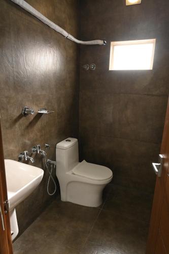 a bathroom with a toilet and a sink at Grace Tourist Home in Ernakulam