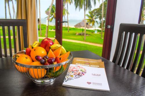 a bowl of fruit sitting on top of a table at Cocoa Luxury Resort, Nyali, Mombasa in Mombasa