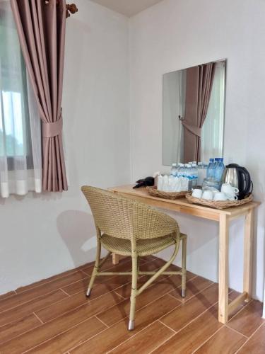 a table with a chair in front of a mirror at ม่านฟ้า โฮมสเตย์ MaanFah Homestay in Chiang Rai