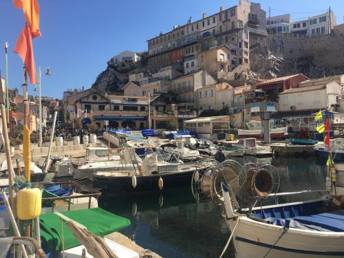 vallon des offs, vue de rêve, 13007 marseille في مارسيليا: مجموعة من القوارب مرساة في ميناء مع مباني