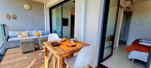 d'un balcon avec une table, des chaises et un canapé. dans l'établissement Appartement central, vue mer, à Porto-Vecchio