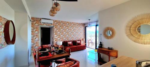 un salon avec un canapé rouge et une table dans l'établissement Appartement central, vue mer, à Porto-Vecchio