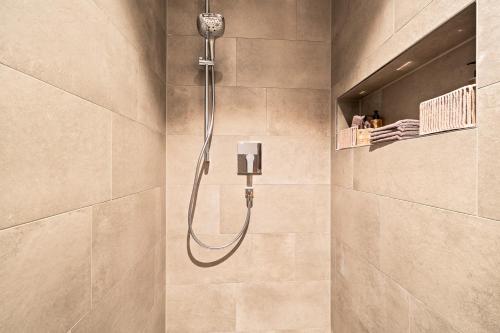 a shower with a shower head in a bathroom at Golden Poodle Luxusappartment am Neuen Schloss Tettang in Tettnang