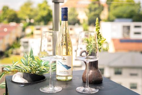 a bottle of wine and two glasses on a table at Golden Poodle Luxusappartment am Neuen Schloss Tettang in Tettnang