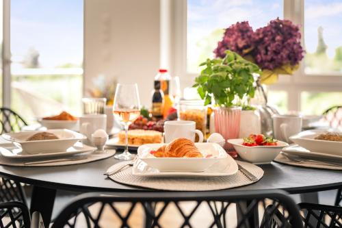 a table with plates of food and wine glasses at Golden Poodle Luxusappartment am Neuen Schloss Tettang in Tettnang