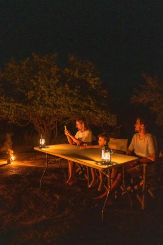 a group of people sitting at a table at night at Yakaduru - Yala in Yala