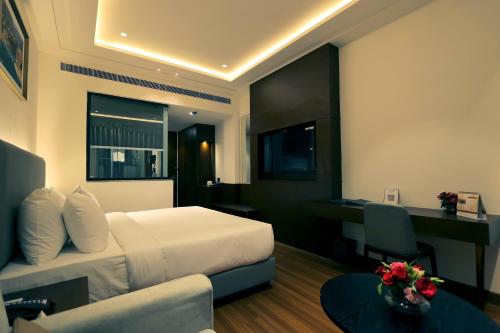 a hotel room with a bed and a desk at Pride Elite Haridwar in Haridwār