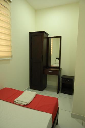 a bedroom with a bed with a mirror and a dresser at Grace Tourist Home in Ernakulam