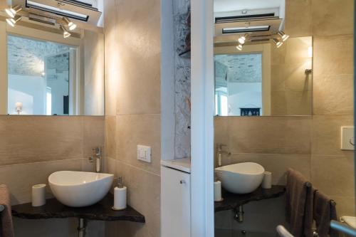 een badkamer met twee wastafels en twee spiegels bij KAMBUSA - Mono Fronte Mare in Santo Stefano al Mare