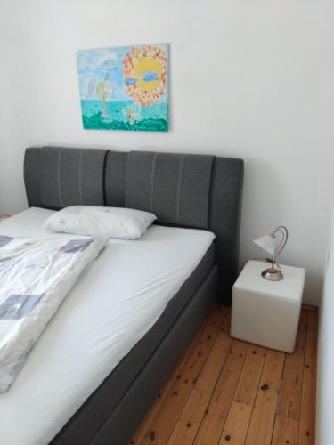een bed met een grijs hoofdeinde in een slaapkamer bij Ferienwohnung Linde bei Ferienwohnungen May in Plankenfels