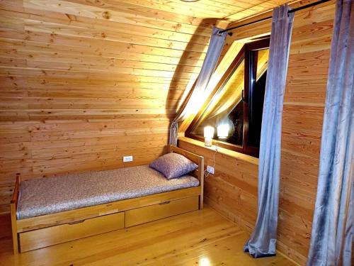 ein Raum mit einer Bank in einer Blockhütte mit einem Fenster in der Unterkunft Brvnara Smrčica in Bajina Bašta