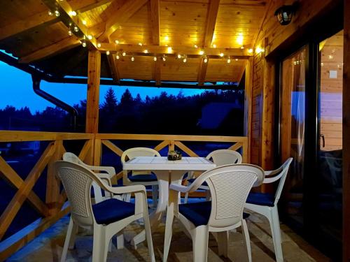 ein Tisch und Stühle auf der Veranda einer Hütte in der Unterkunft Brvnara Smrčica in Bajina Bašta