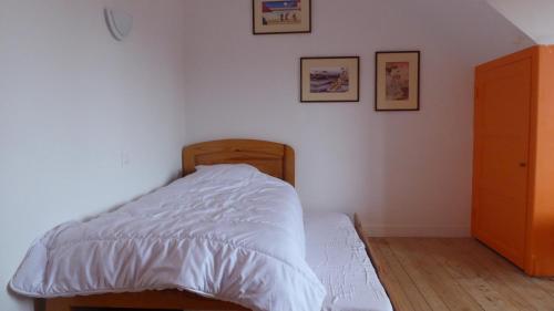 une chambre avec un lit avec une couette blanche dans l'établissement Gîte Saint Esprit des Bois, à Plédèliac