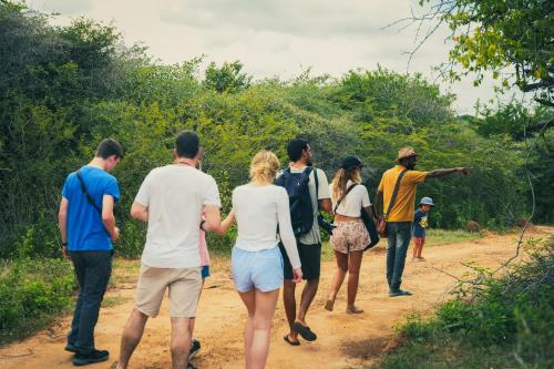a group of people walking down a dirt road at Yakaduru - Yala in Yala