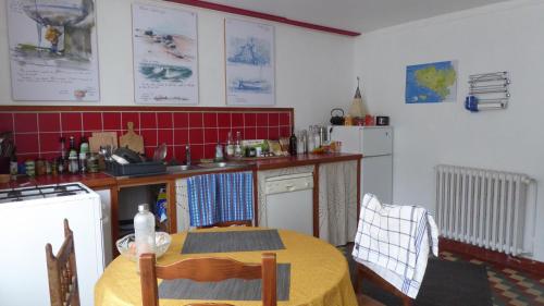 une cuisine avec une table et un chiffon de table jaune dans l'établissement Gîte Saint Esprit des Bois, à Plédèliac