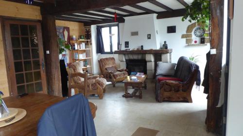 un salon rempli de meubles et d'une cheminée dans l'établissement Gîte Saint Esprit des Bois, à Plédèliac