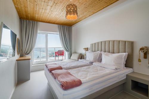 a bedroom with a large bed with a large window at Villa Kalimera in Balchik
