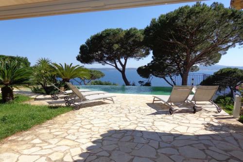 - un ensemble de chaises assises sur une terrasse avec piscine dans l'établissement Vue sur St Tropez, à Sainte-Maxime