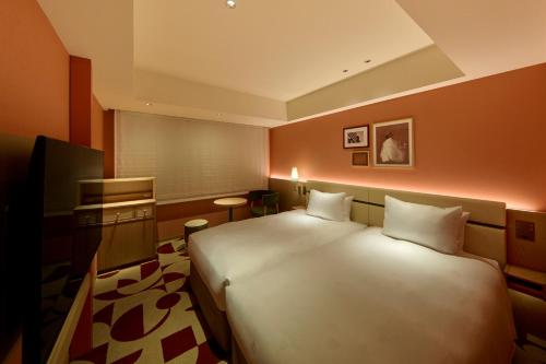a bedroom with a large white bed in a room at The Royal Park Hotel Ginza 6-Chome in Tokyo