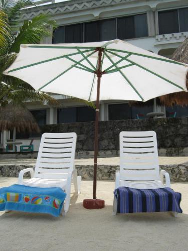 twee stoelen en een parasol op het strand bij Condumel in Cozumel