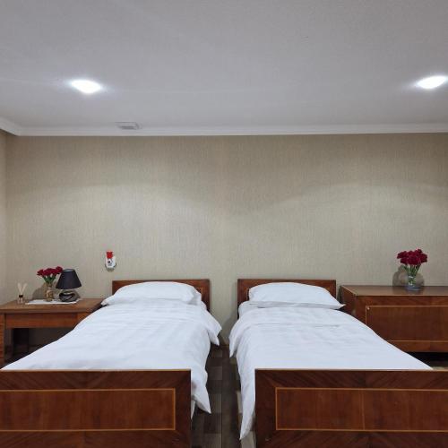 a bedroom with two beds and two night stands at Colchis Guest House in Tskaltubo