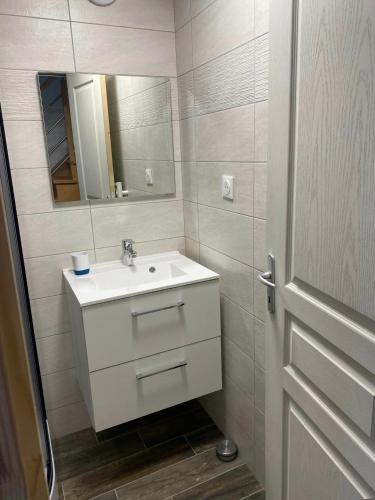 une salle de bain avec un lavabo blanc et un miroir dans l'établissement Café de la Liberté, à Sainte-Mère-Église