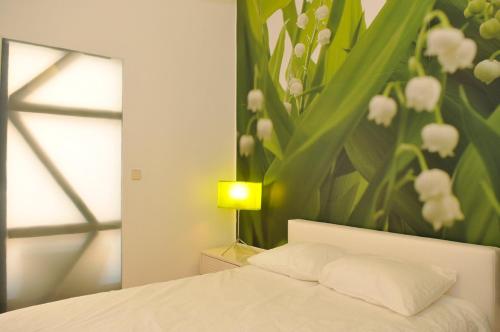 - une chambre avec un lit orné d'une peinture florale sur le mur dans l'établissement Baixa Cosy, à Lisbonne