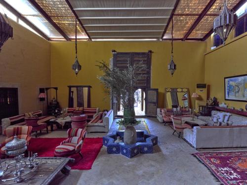 a living room with couches and chairs and a plant at Kasbah Agafay Hotel & Spa in El Karia