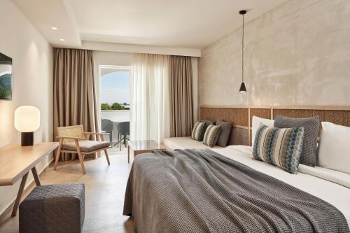 a hotel room with a bed and a desk at Atlantica Marmari Palace in Mastichari