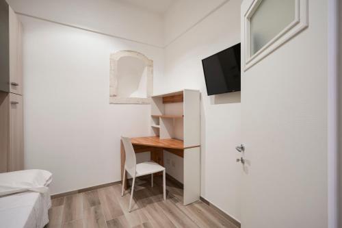 a small room with a desk and a tv on a wall at La Dimora del Sole Pugliese in Casamassima