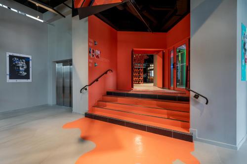 a hallway with red walls and stairs in a building at Aloft Hotel, By Marriott in Dijon