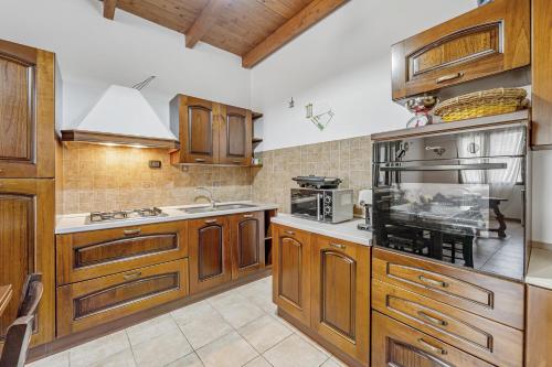 a kitchen with wooden cabinets and a stove top oven at Casa rustica in Gonnesa