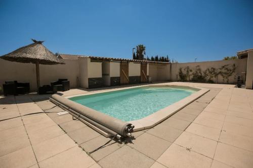 - une piscine sur une terrasse avec un parasol dans l'établissement Maison 4 chambres avec piscine, à Saint-Gilles