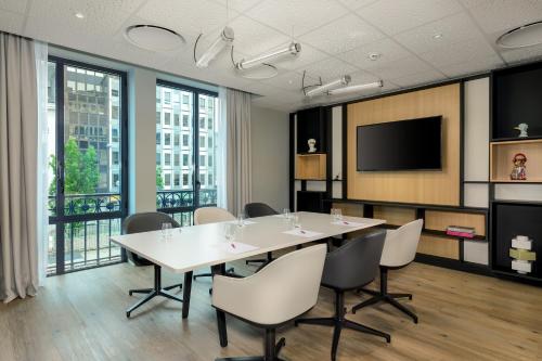 a conference room with a table and chairs and a tv at Aloft Hotel, By Marriott in Dijon