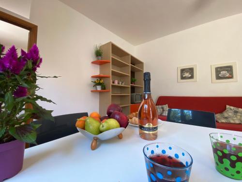 a table with a bowl of fruit and a bottle of wine at A Casa di Alfredo Depandance in villa in Lecce