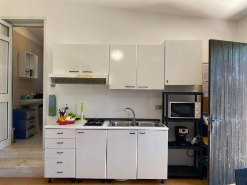 a kitchen with white cabinets and a sink at A Casa di Alfredo Depandance in villa in Lecce
