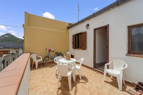 a patio with a table and chairs on a balcony at Casa rustica in Gonnesa