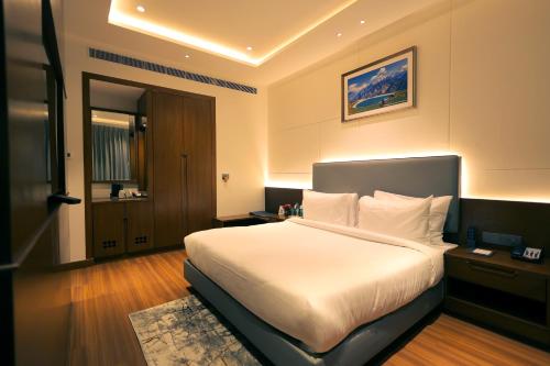 a bedroom with a large white bed in a room at Pride Elite Haridwar in Haridwār