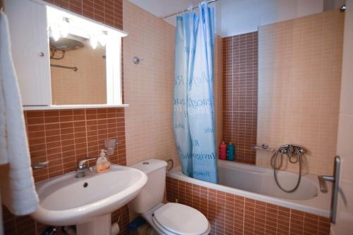 a bathroom with a toilet and a sink and a tub at thalassa home in Nikiana