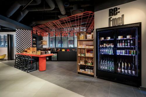 a restaurant with a counter and a bar with drinks at Aloft Hotel, By Marriott in Dijon