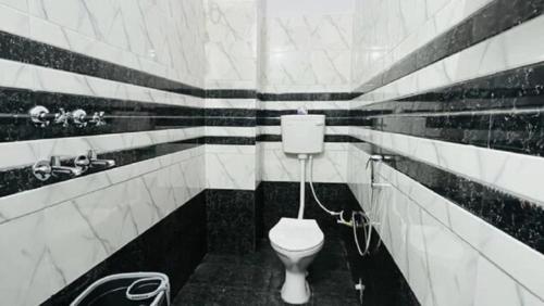 - une salle de bains en noir et blanc avec des toilettes dans l'établissement Goroomgo Ram Krishna Palace Ayodhya - Luxury Room - Top Rated and Most Awarded Hotel in Ayodhya - Best Seller, à Ayodhya