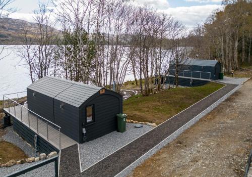 a tiny house next to a body of water at Nessie Pod in Fort Augustus