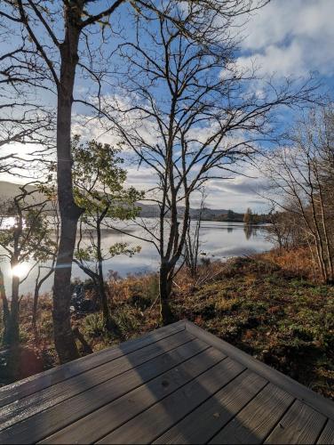 a wooden deck with a view of a lake at Nessie Pod in Fort Augustus