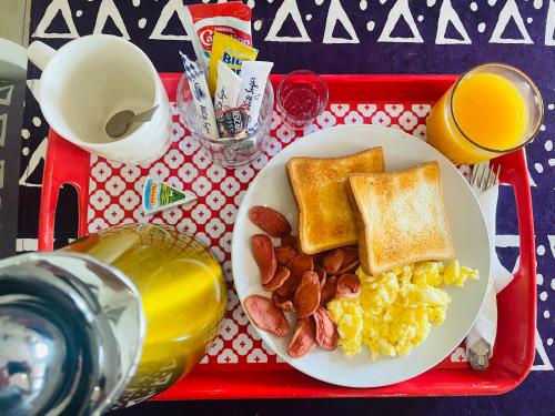 a red tray with a plate of breakfast foods and drinks at LA SUNSET in Accra