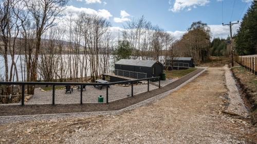 a fence in front of a body of water at Nessie Pod in Fort Augustus