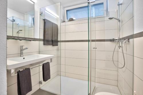 uma casa de banho com uma cabina de duche em vidro e um lavatório. em Hotel Restaurant Berghaus Malbun Buchserberg em Buchs