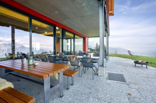 an outdoor patio with a wooden table and chairs at Hotel Restaurant Berghaus Malbun Buchserberg in Buchs