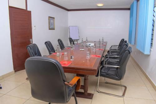 a conference room with a long wooden table and chairs at Cocoa Luxury Resort, Nyali, Mombasa in Mombasa