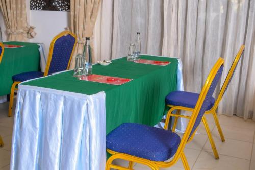 a table with a green table cloth and chairs at Cocoa Luxury Resort, Nyali, Mombasa in Mombasa