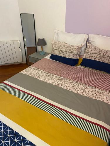 - une chambre avec un lit doté d'un couvre-lit multicolore dans l'établissement Appartement lumineux 4 personnes, à Enghien-les-Bains